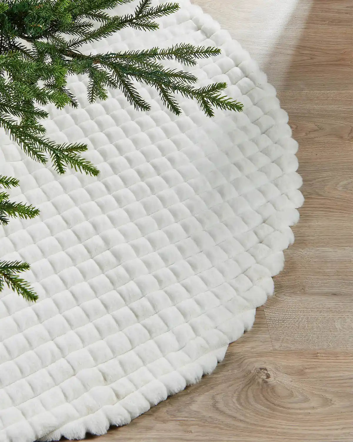 White diamond faux fur tree skirt on light wood flooring