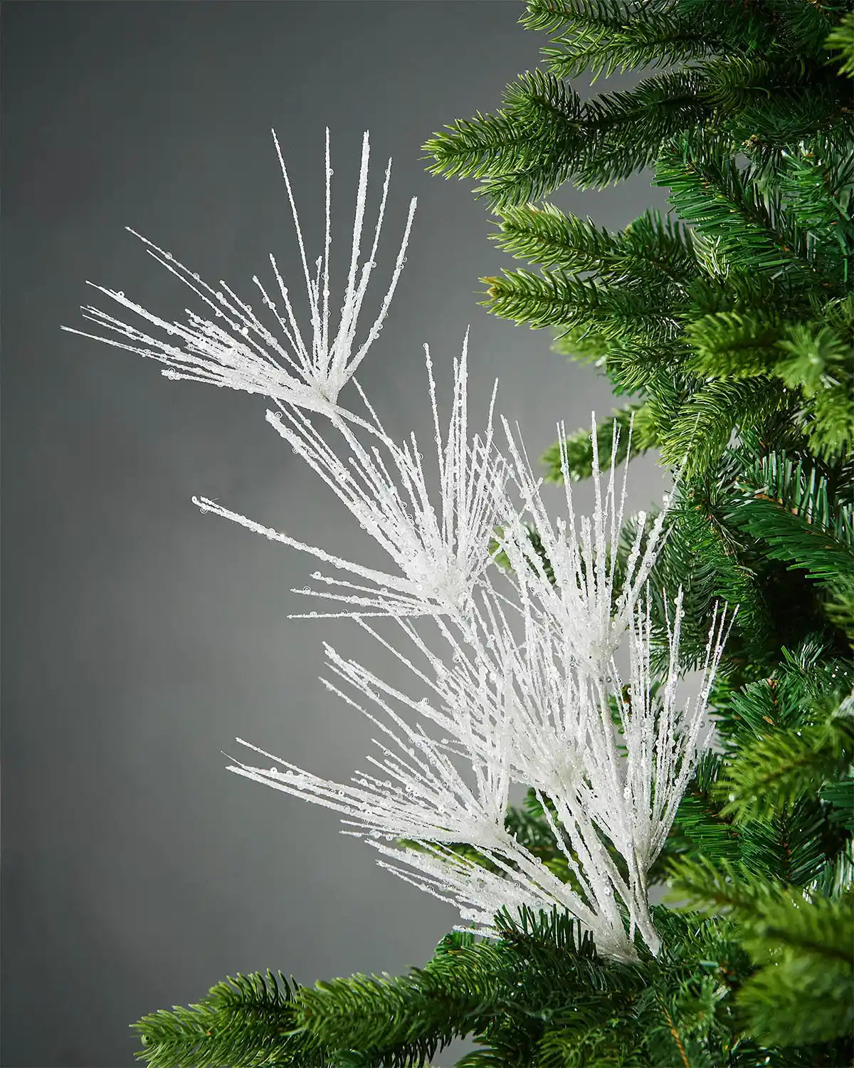 White glitter firework spray in Christmas tree in front of grey background