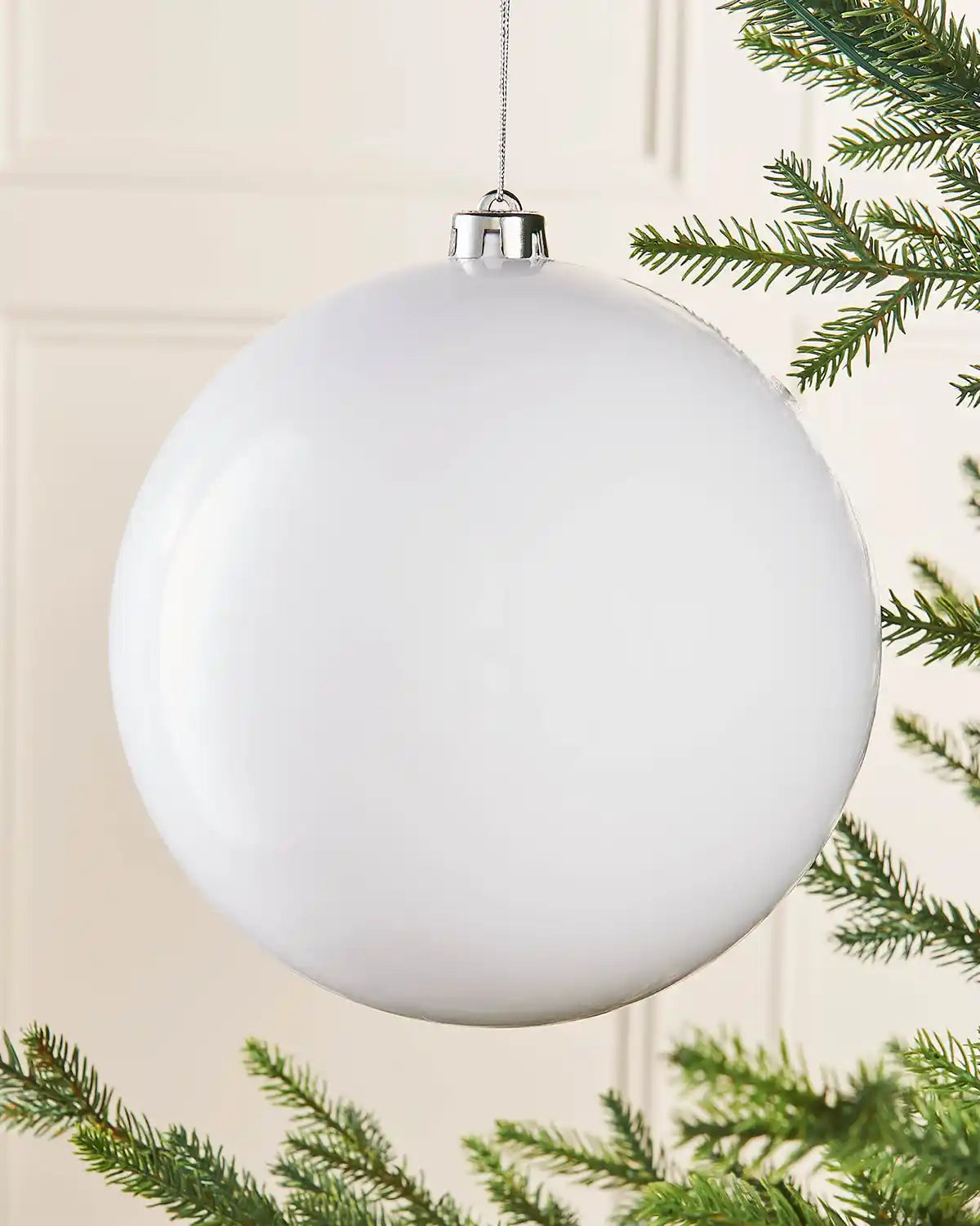 White oversized gloss bauble on a Christmas tree