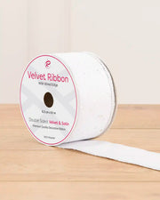 White sequin ribbon on a wooden table against a light background