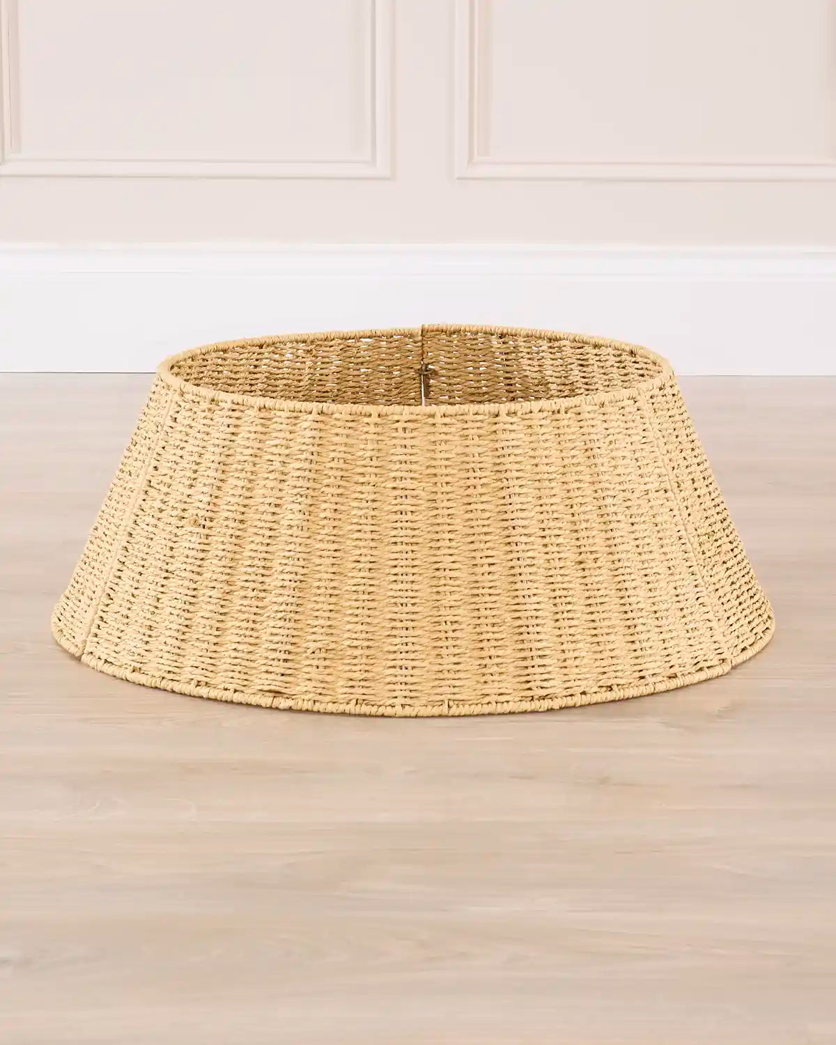 Woven rattan tree collar shown from the front, highlighting its tapered shape and open top