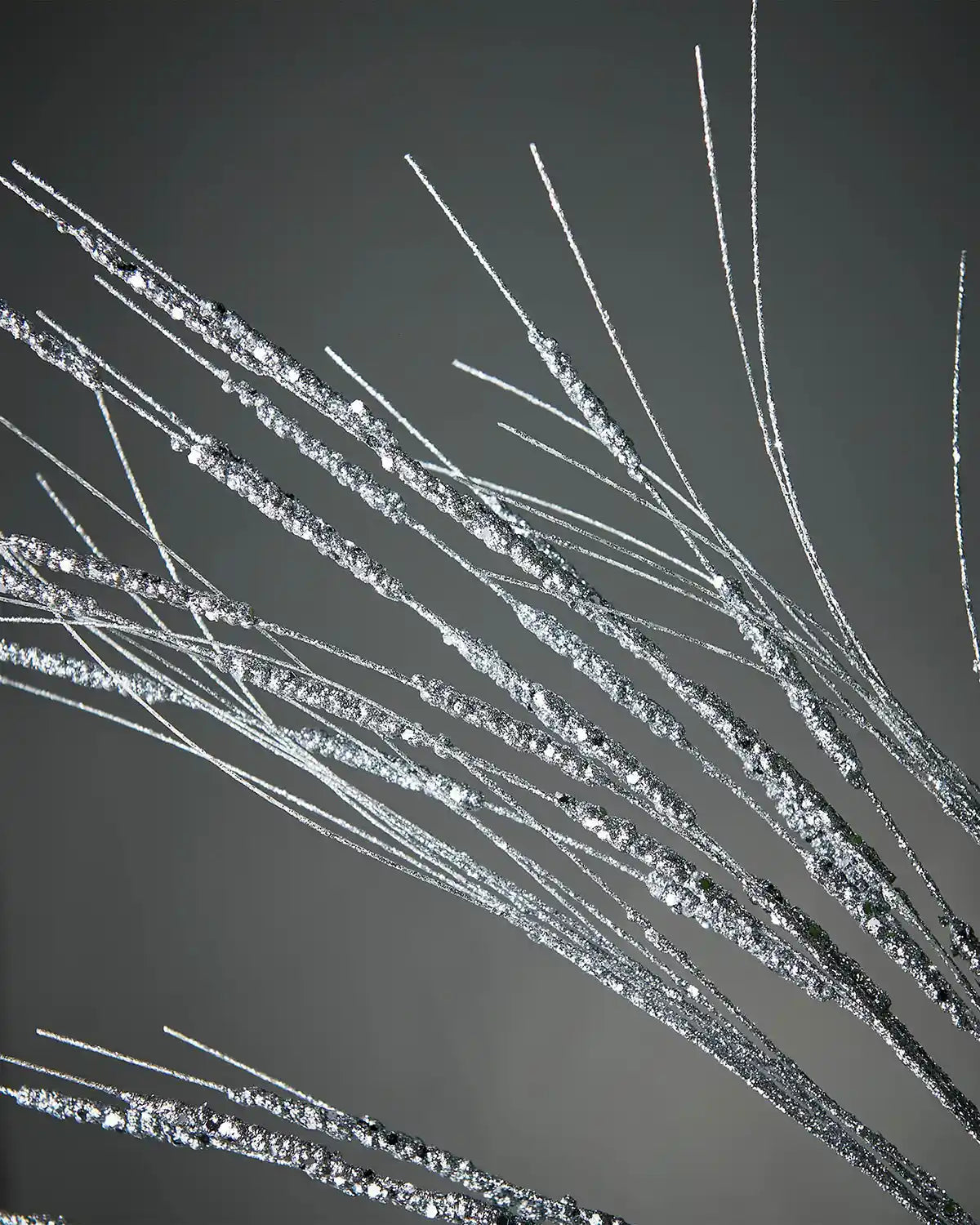 Zoomed-in image of 100cm silver glitter wispy spray in front of grey background