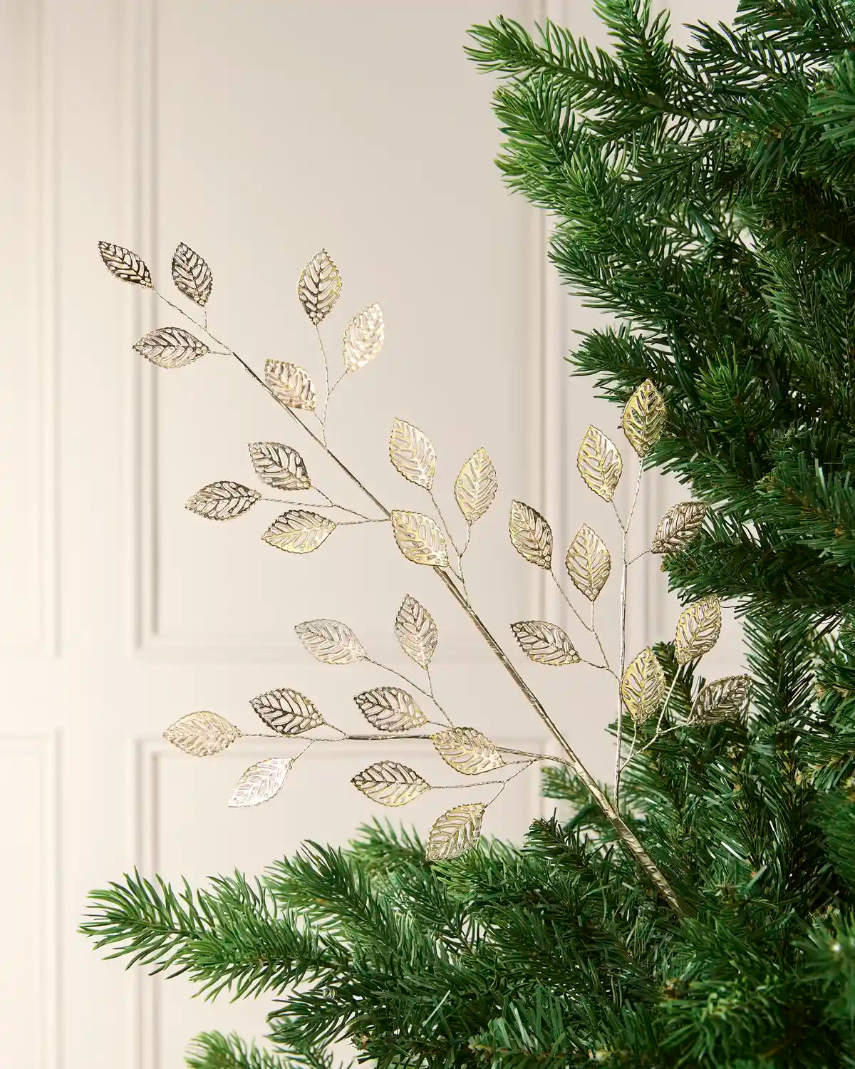 65 cm antique gold leaf pick arranged among green Christmas tree branches.