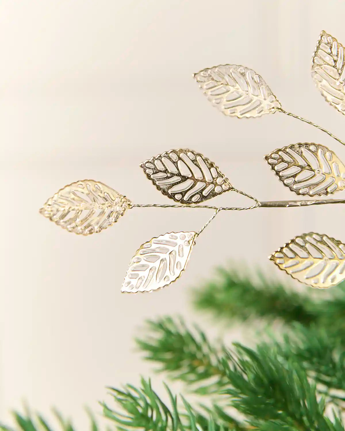 Close-up of antique gold leaf decorations showing cut-out vein details and metallic edges.