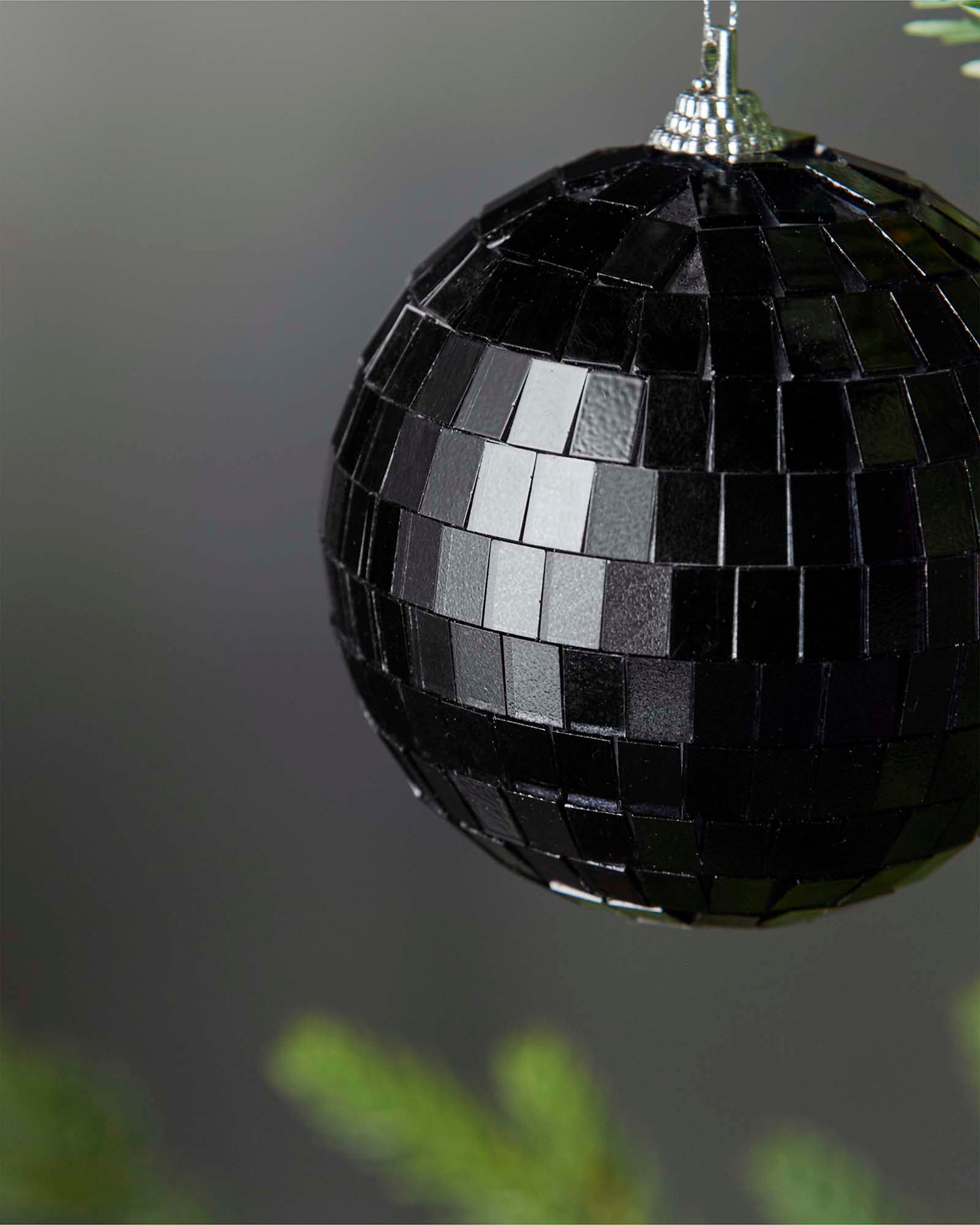 Close-up of a black 8cm disco ball bauble with mirrored square detailing.