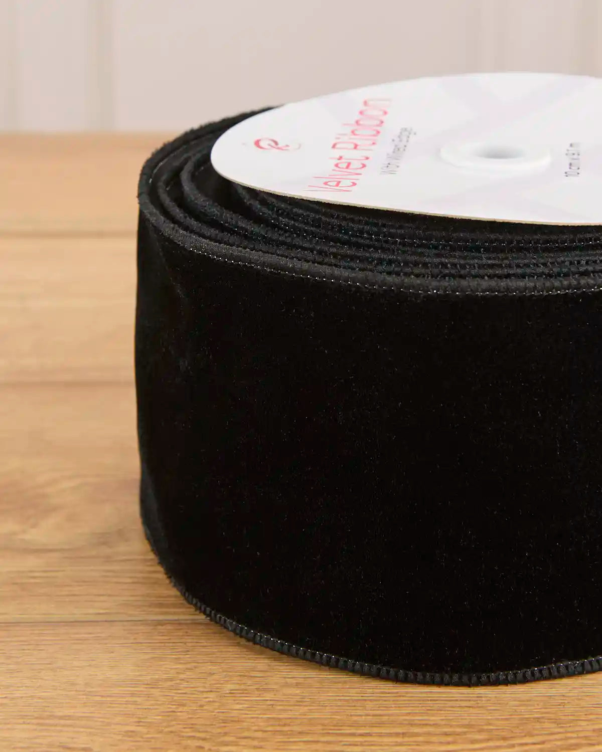 Close-up of the black velvet surface and wired satin edging on the 10 cm ribbon.
