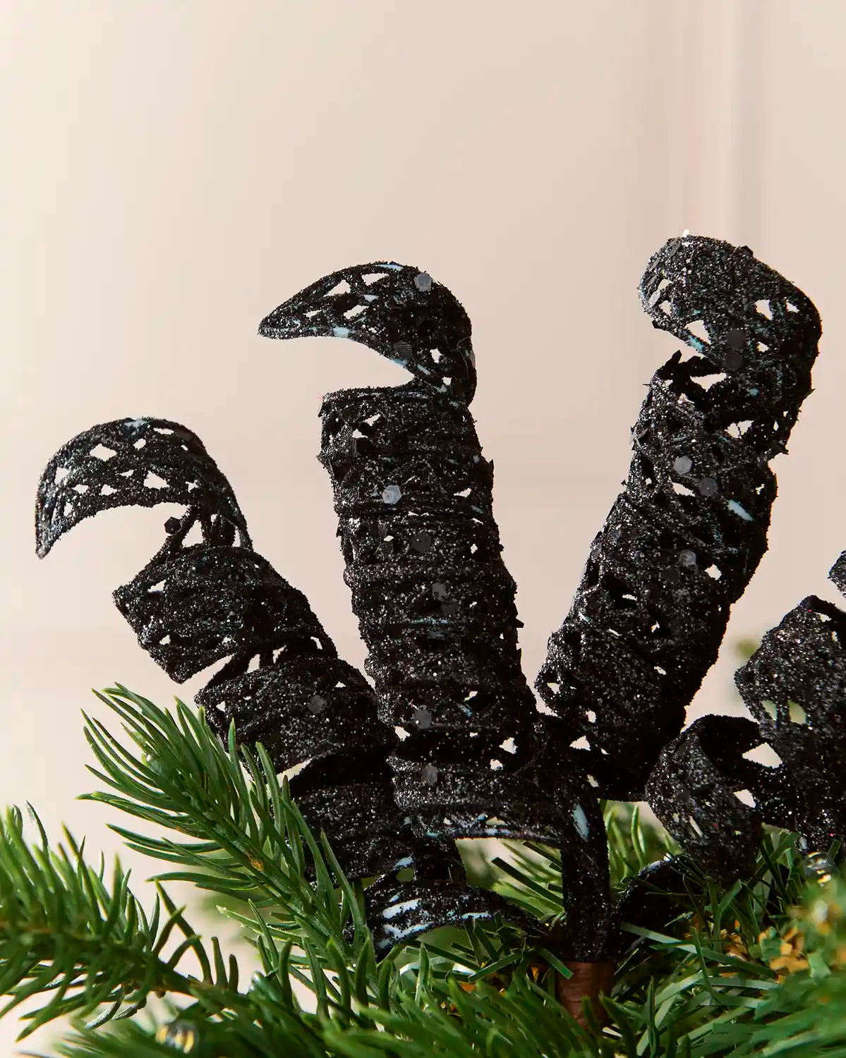 Close-up of black glitter spiral picks showing curled openwork shapes and reflective sequin details.