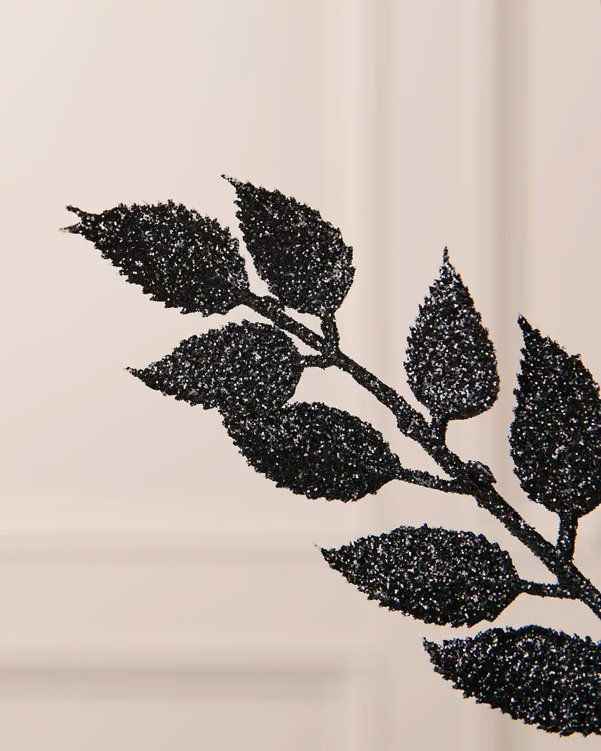 Detailed close-up of the sparkling black leaves on the 73 cm Christmas tree spray.