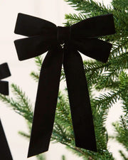 Black 16.5 cm velvet double bow with long tails attached to a Christmas tree branch.