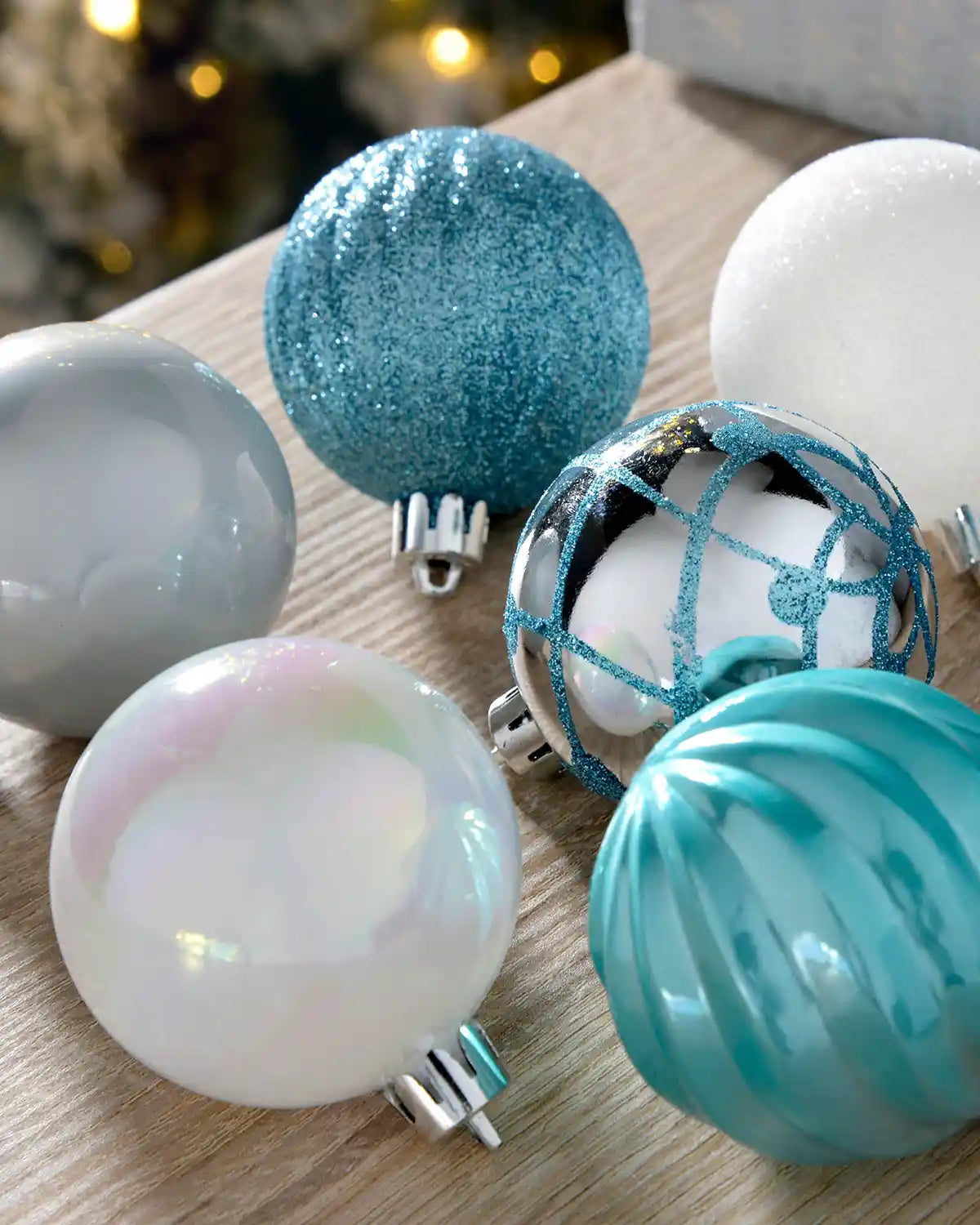 Close-up of blue, white and silver 6cm baubles with glitter, pearl and ribbed finishes