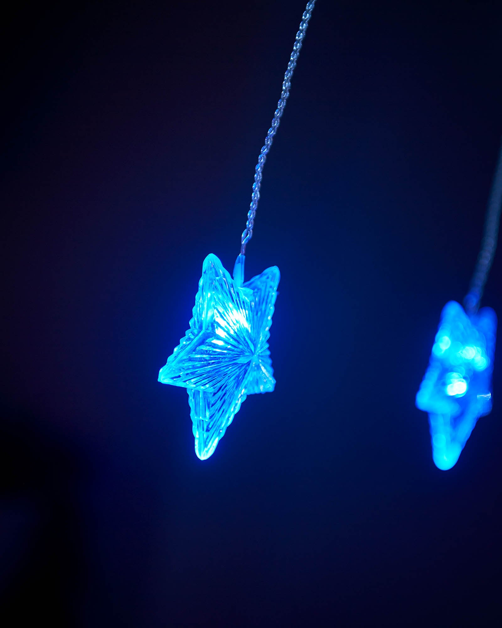 Close-up of blue star curtain net lights with white star lights in the background