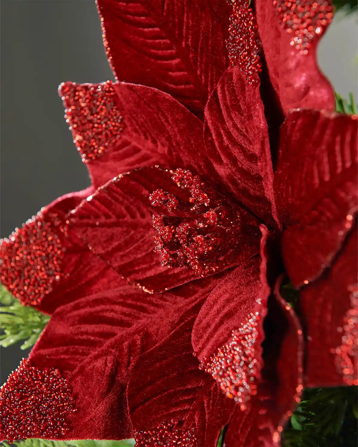 Close-up of a 32 cm burgundy artificial poinsettia flower showing red glittered petal tips and a matching glittered stigma.