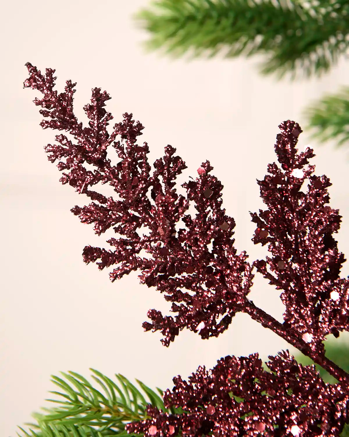 Close-up of burgundy glitter leaf foliage with reflective sequins and a sparkling finish.