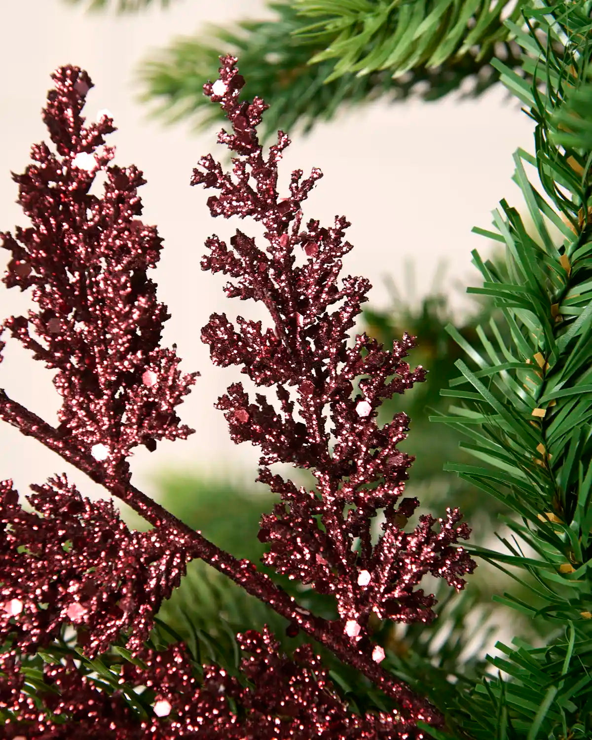 Close-up of a burgundy glitter leaf pick showing sparkling foliage and reflective sequin detail.