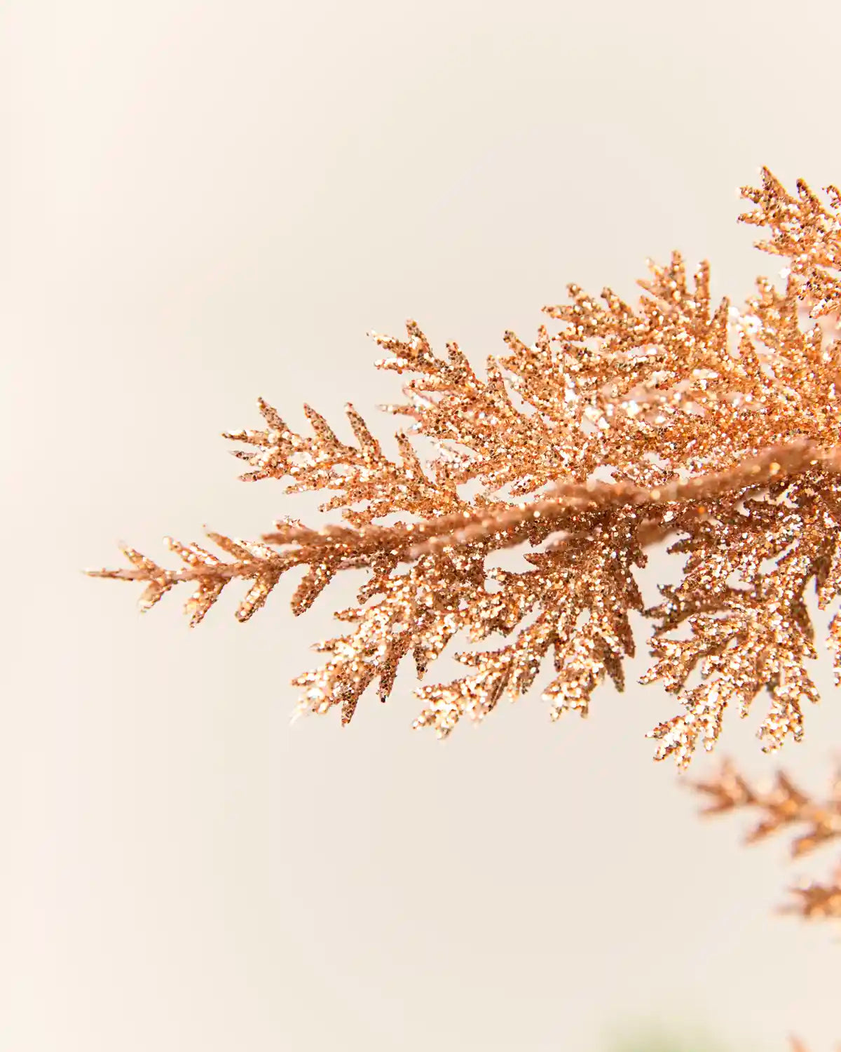 close-up of the Rose gold Christmas tree spray to highlight its textured, shimmering leaves