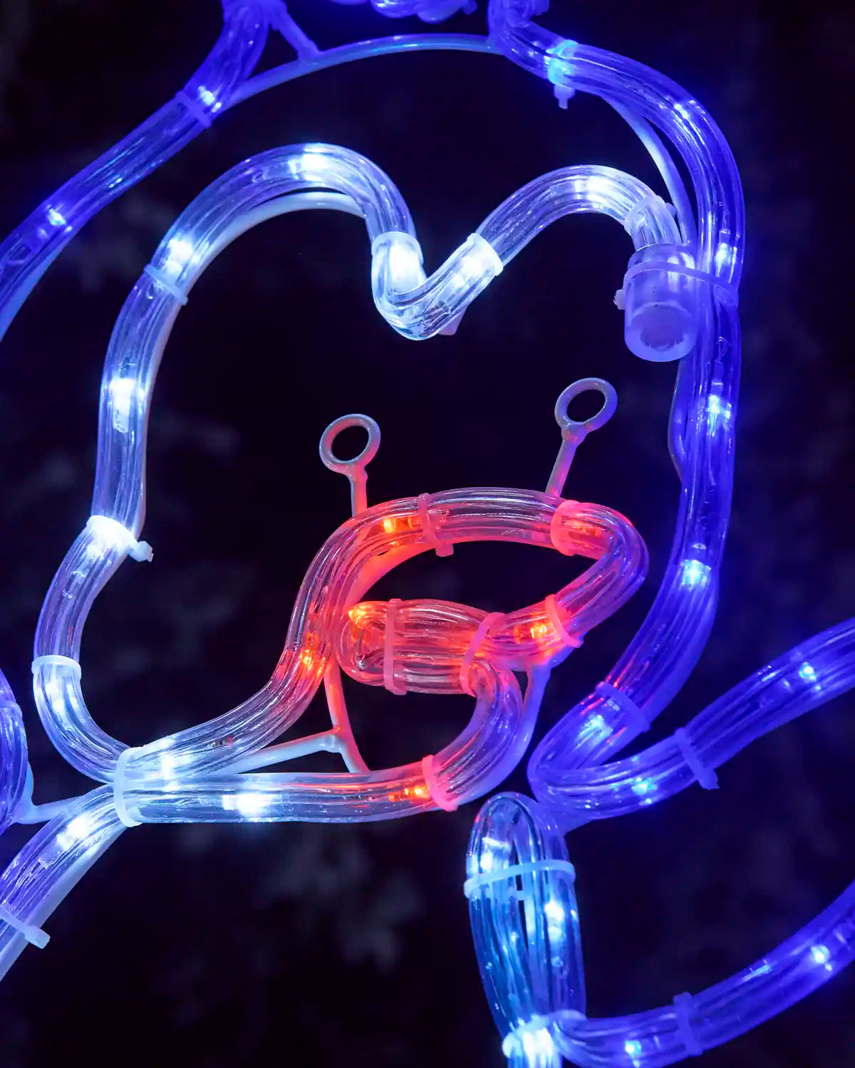 close-up of the pre-lit penguin rope light silhouette showing its glowing red beak, white face, and blue outline