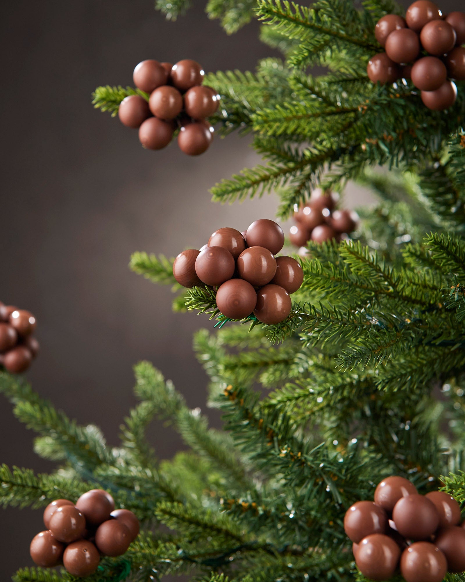 Espresso glass berry cluster baubles arranged on a green Christmas tree.