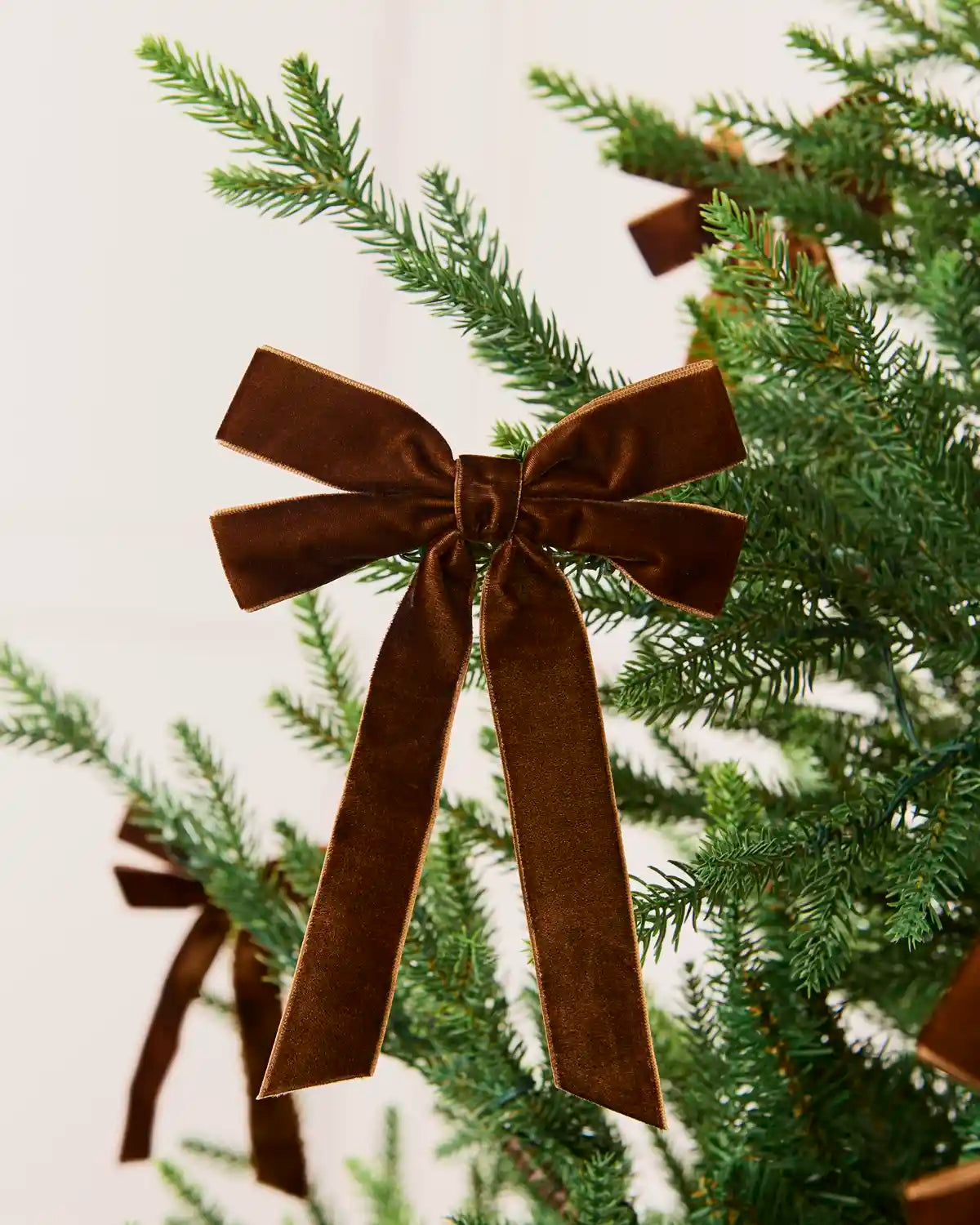 Espresso velvet double bow displayed among matching bows on a Christmas tree.