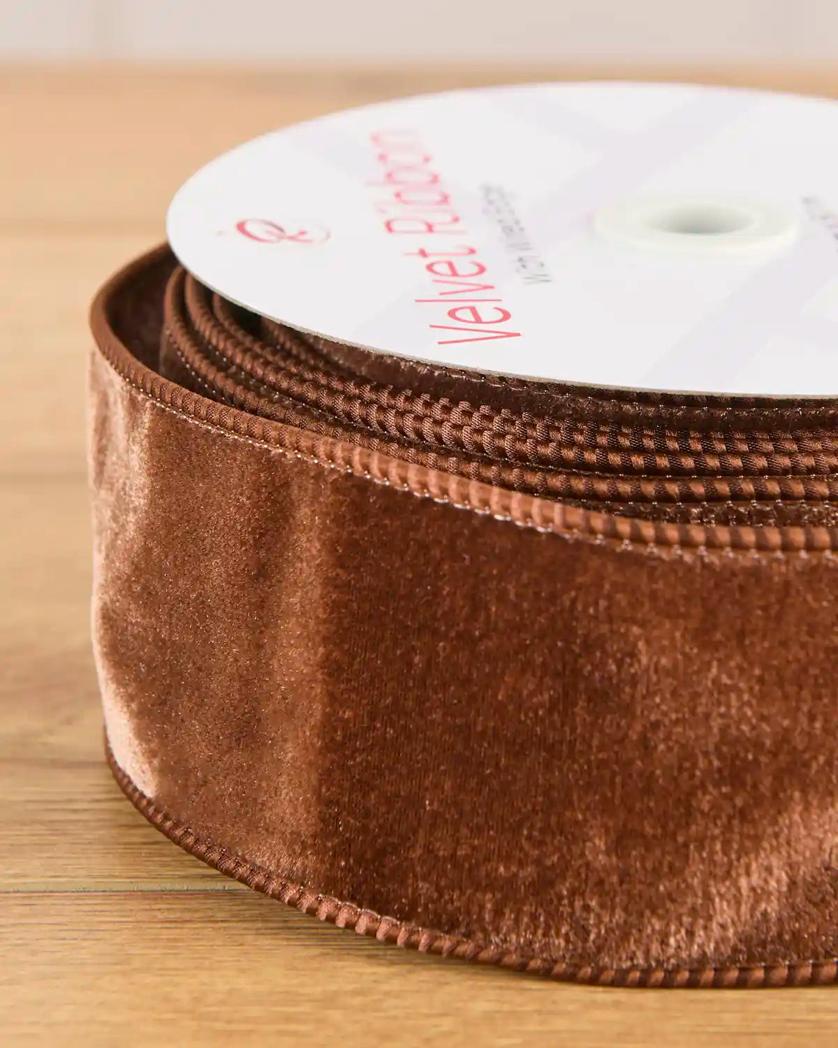 Close-up of 6 cm wide espresso velvet ribbon showing its soft surface and wired edges.