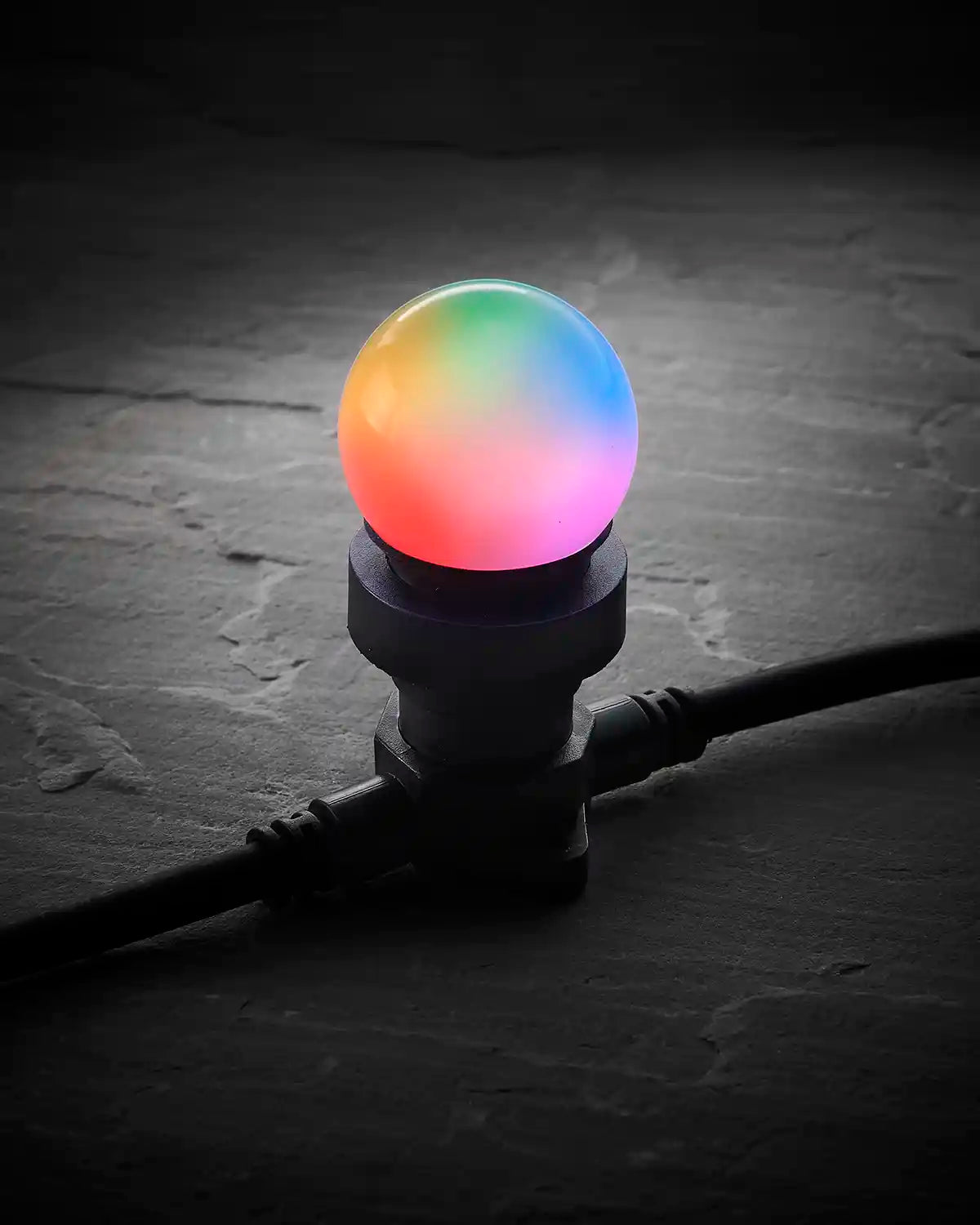 Colour-changing E27 LED festoon bulb glowing with rainbow colours in a black festoon socket.