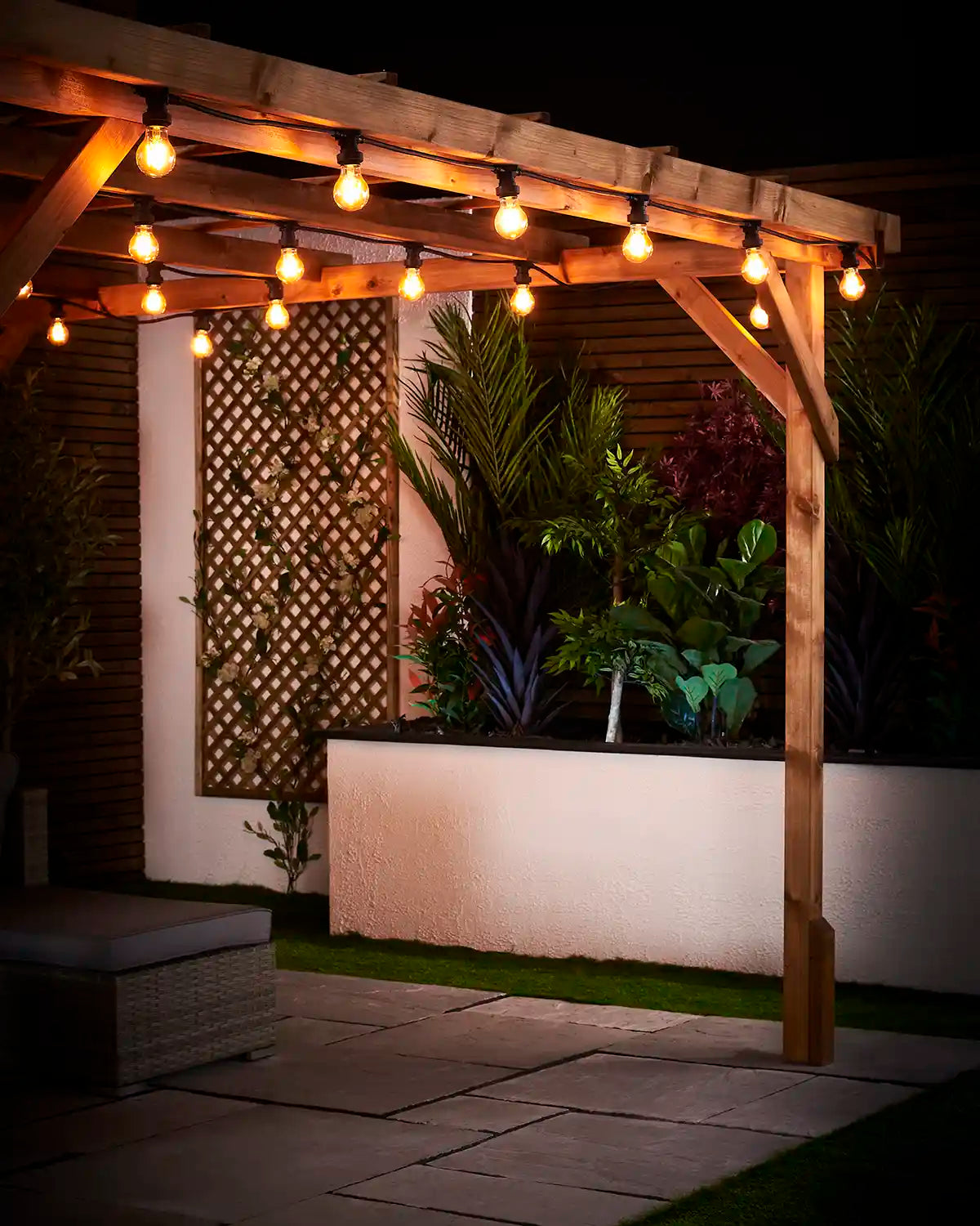 Warm white E27 filament bulbs fitted along a wooden pergola beside garden planting and wall trellis.