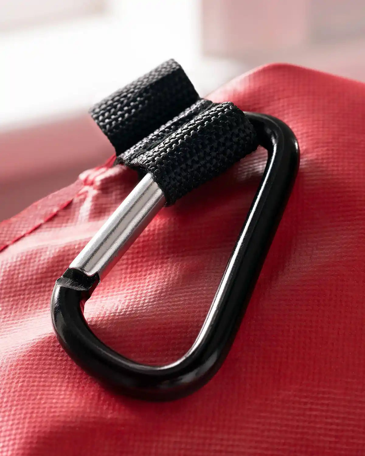 Close-up of the carabiner clip on the red garland and wreath storage bag