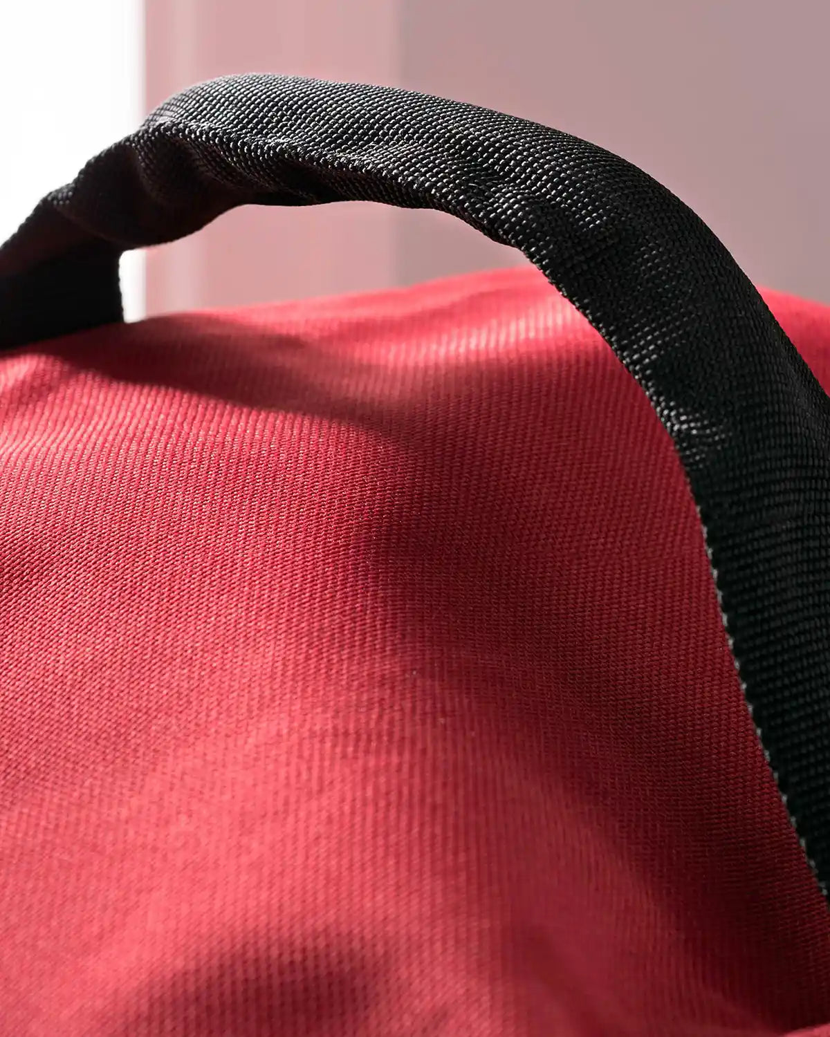 Close-up of the black carry handle on the red storage bag