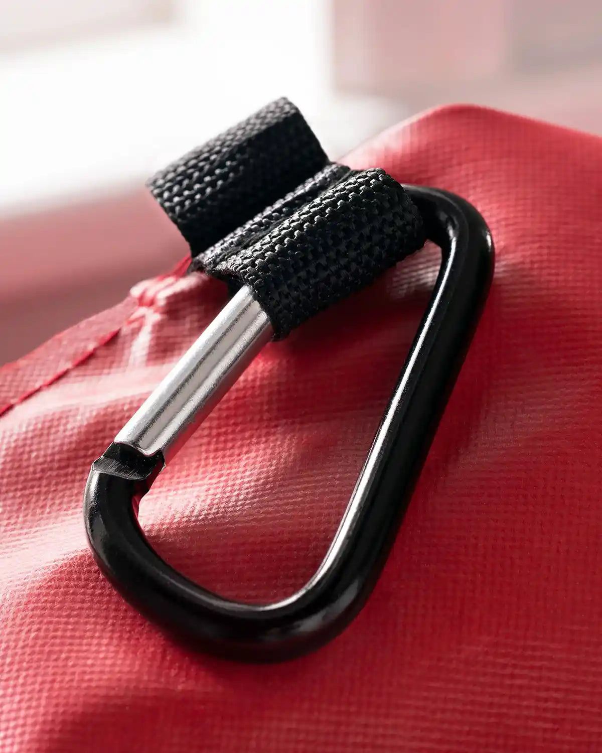 Close-up of the carabiner clip on the red garland and wreath storage bag