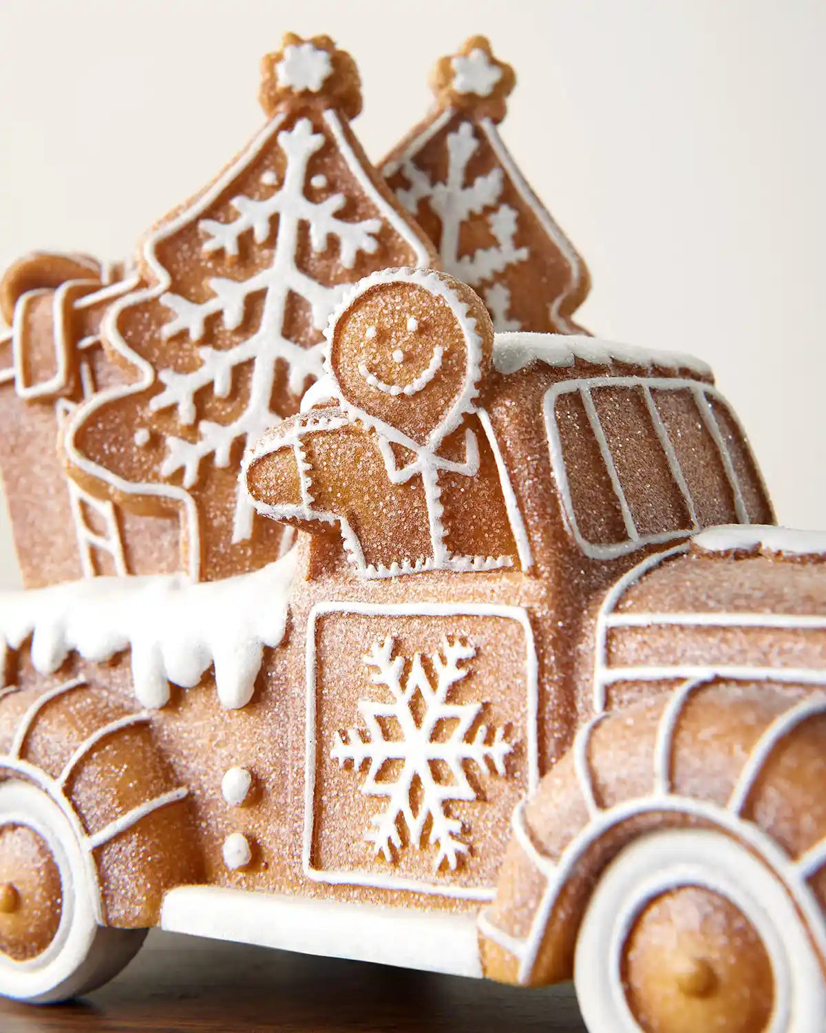 Close-up of the gingerbread car decoration showing the gingerbread figure, snowflake detail and glitter finish.