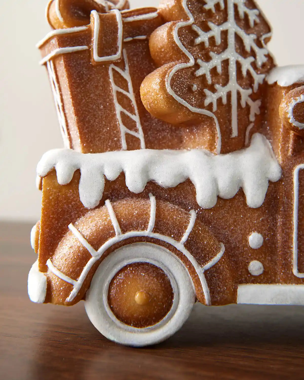 Close-up of the 21cm gingerbread car decoration showing the rear wheel, icing trim and snowy roof detail.