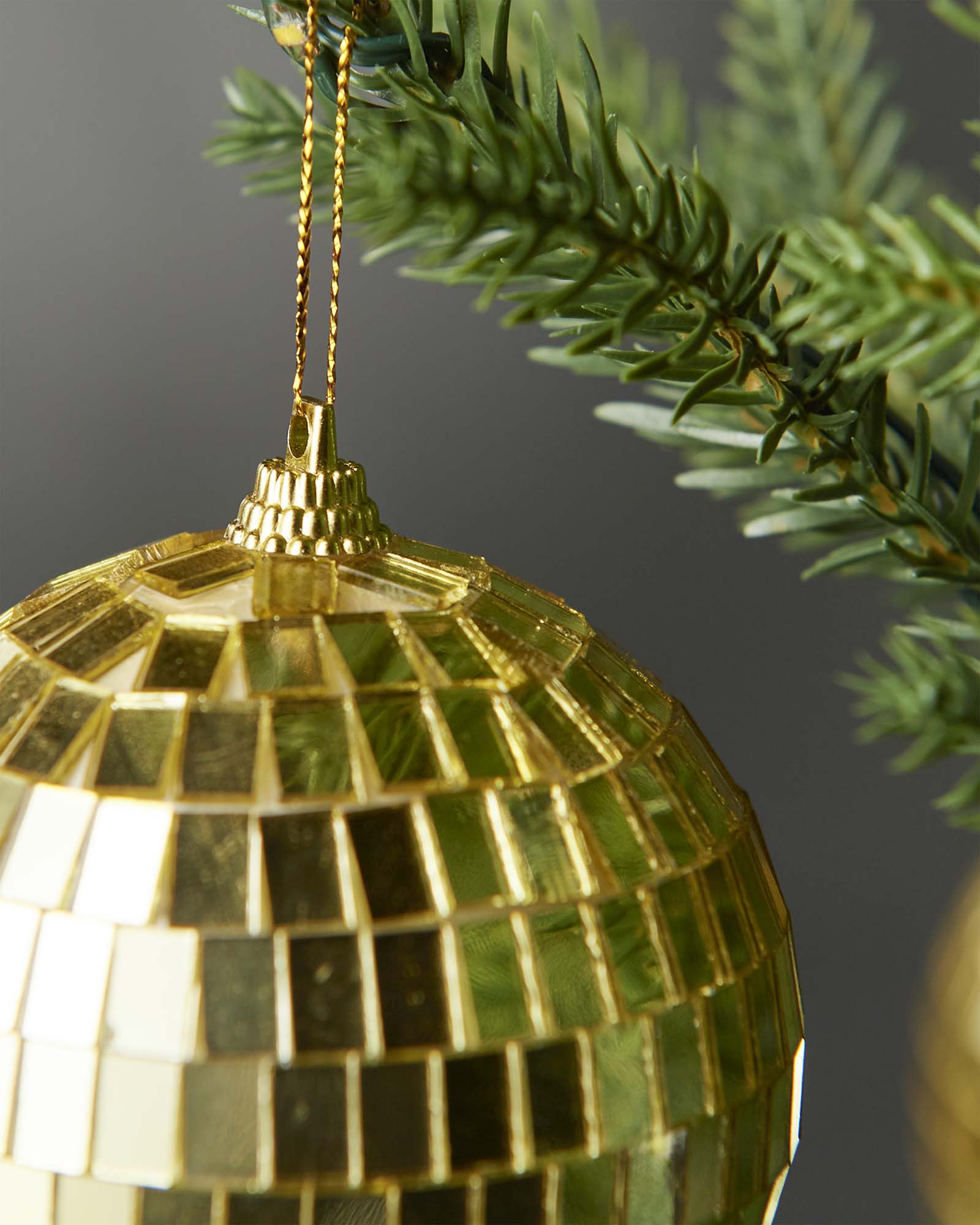Close-up of the gold hanging string and top cap on a gold 8cm disco ball bauble.