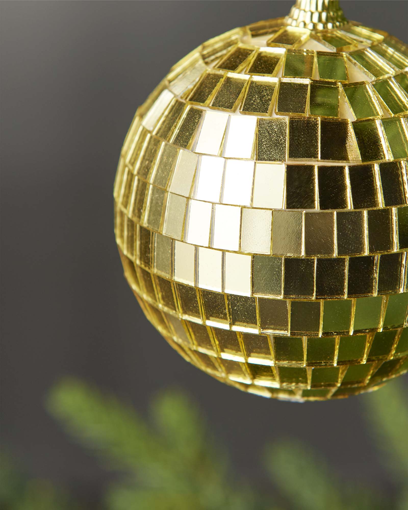 Close-up of a gold 8cm disco ball bauble with mirrored square detailing.
