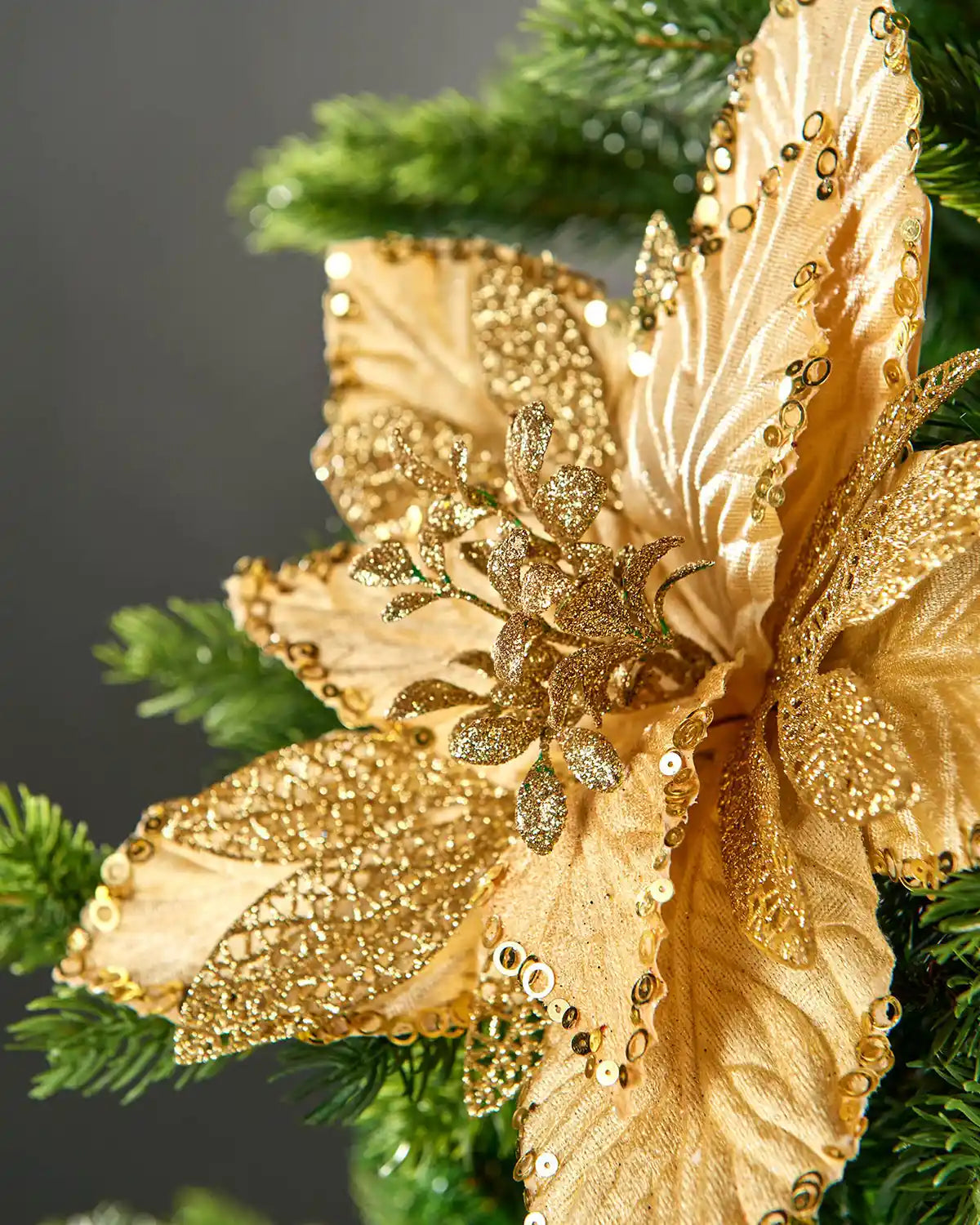 Close-up of the gold poinsettia centre with glittered stigma, lace-style leaves and sequin-trimmed petals.