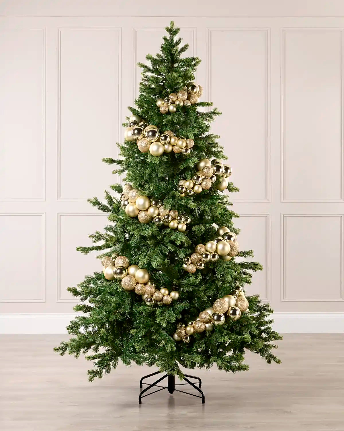 Gold bauble cluster arch styled around a green Christmas tree with shiny, matt and glitter baubles.