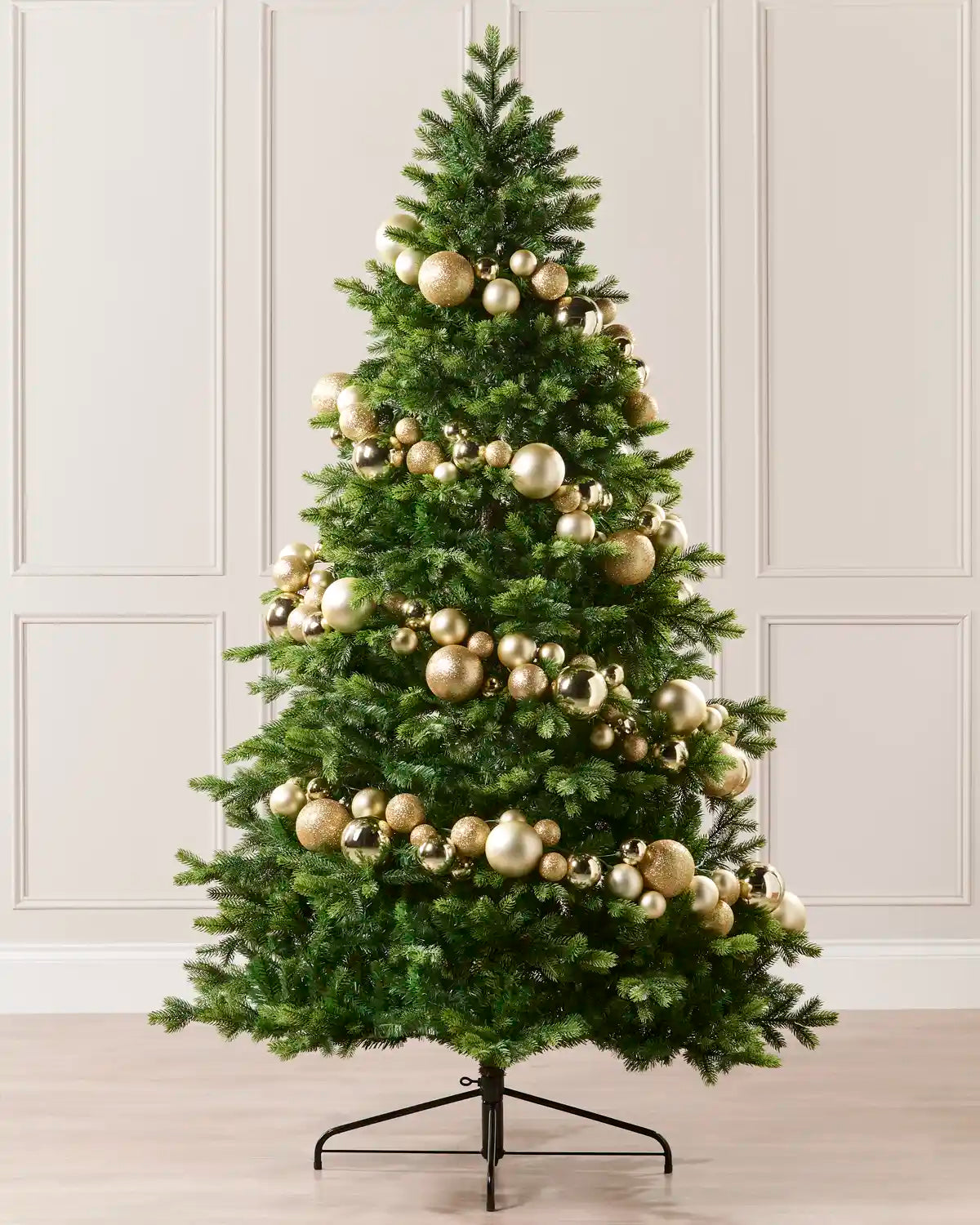 Gold bauble garland wrapped around a green Christmas tree with mixed shiny, matt and glitter baubles.