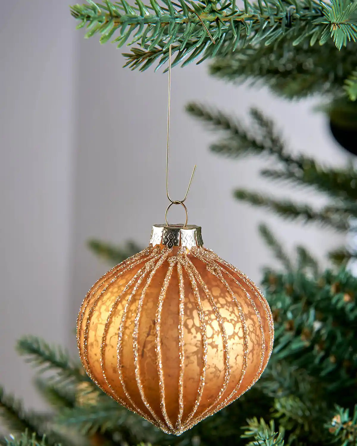 Gold bauble ornament hook hanging a bauble on a Christmas tree