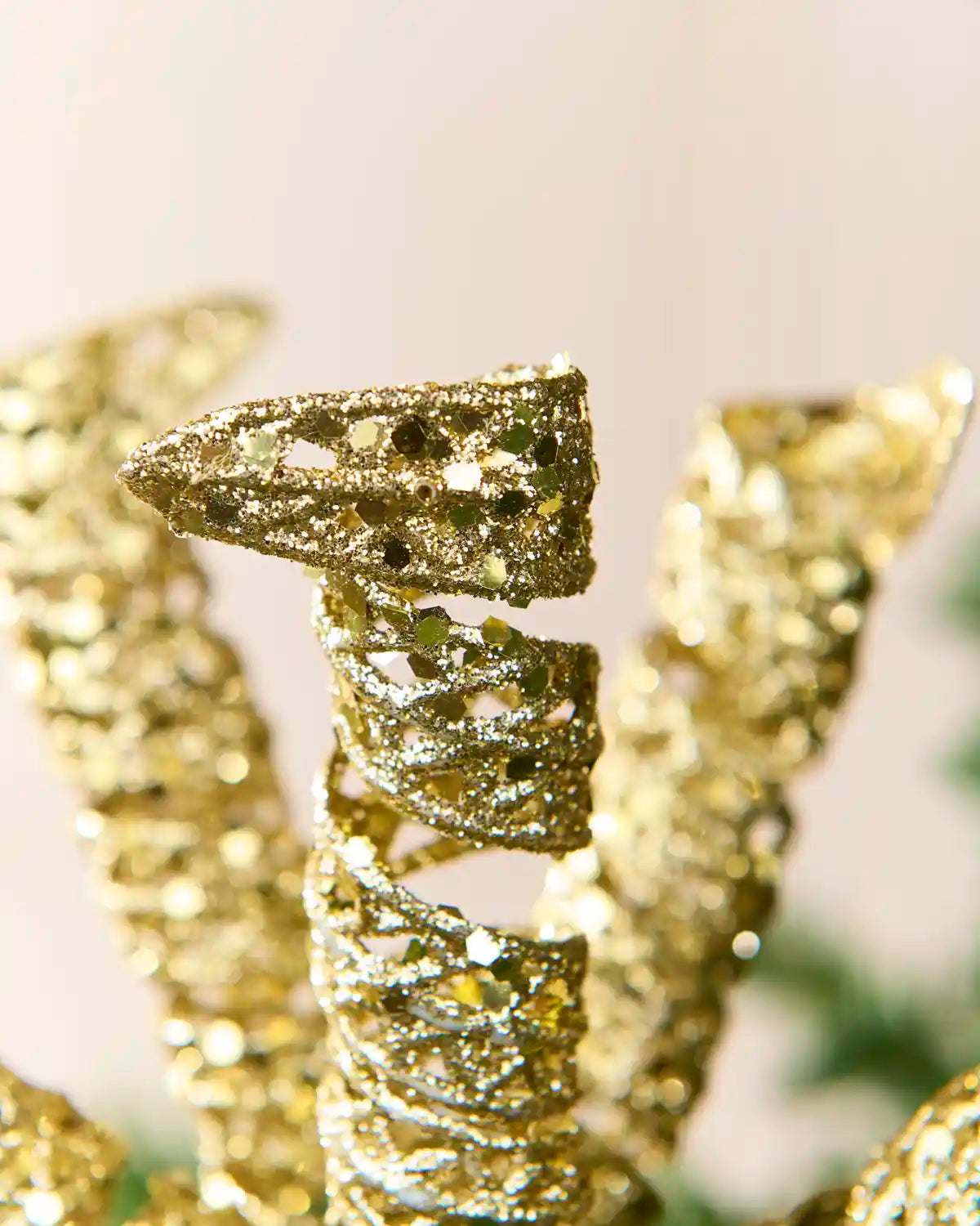 Close-up of gold glitter spiral picks showing curled openwork shapes and reflective sequin details.