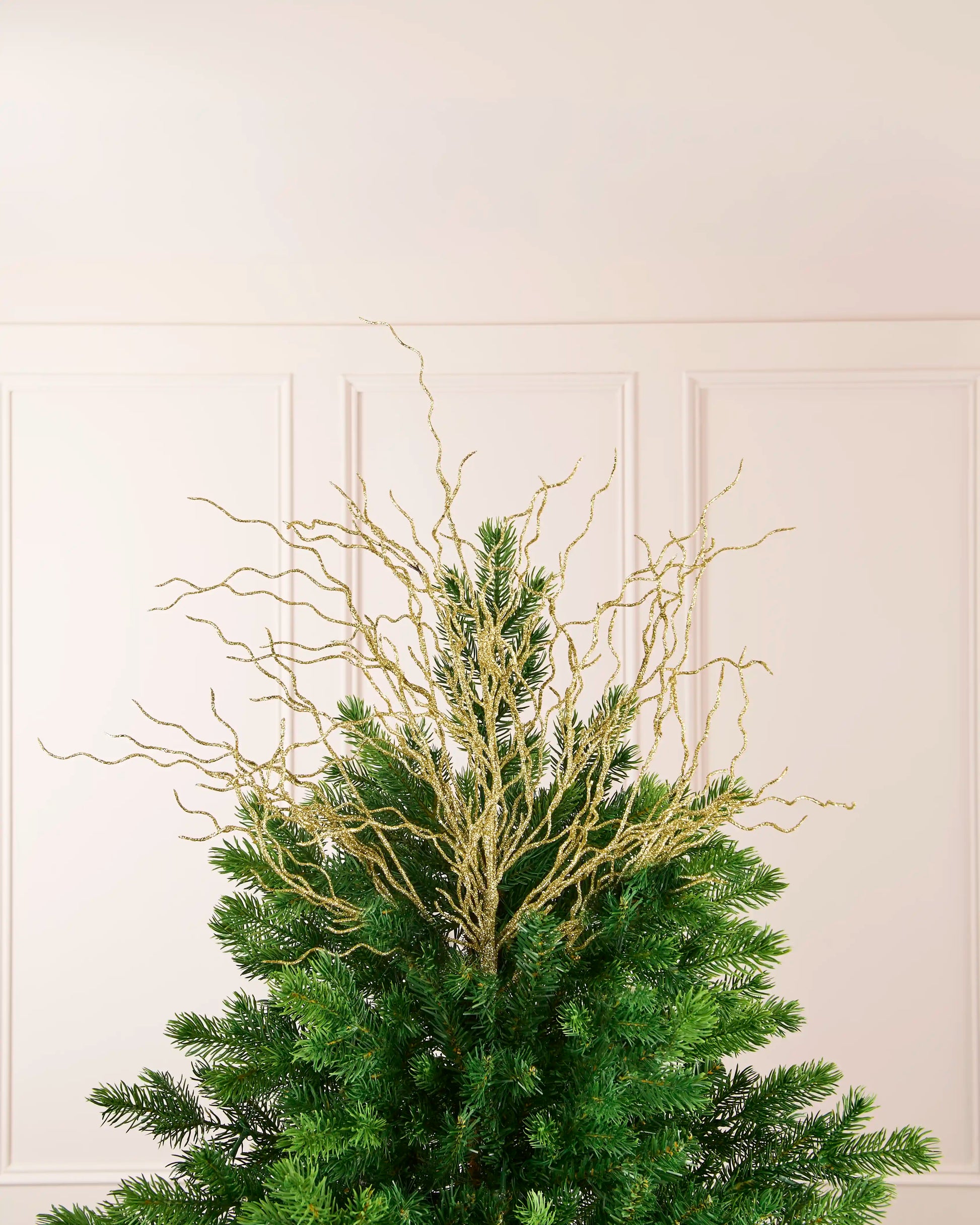 Gold 90 cm glitter twig tree topper arranged at the top of a Christmas tree.