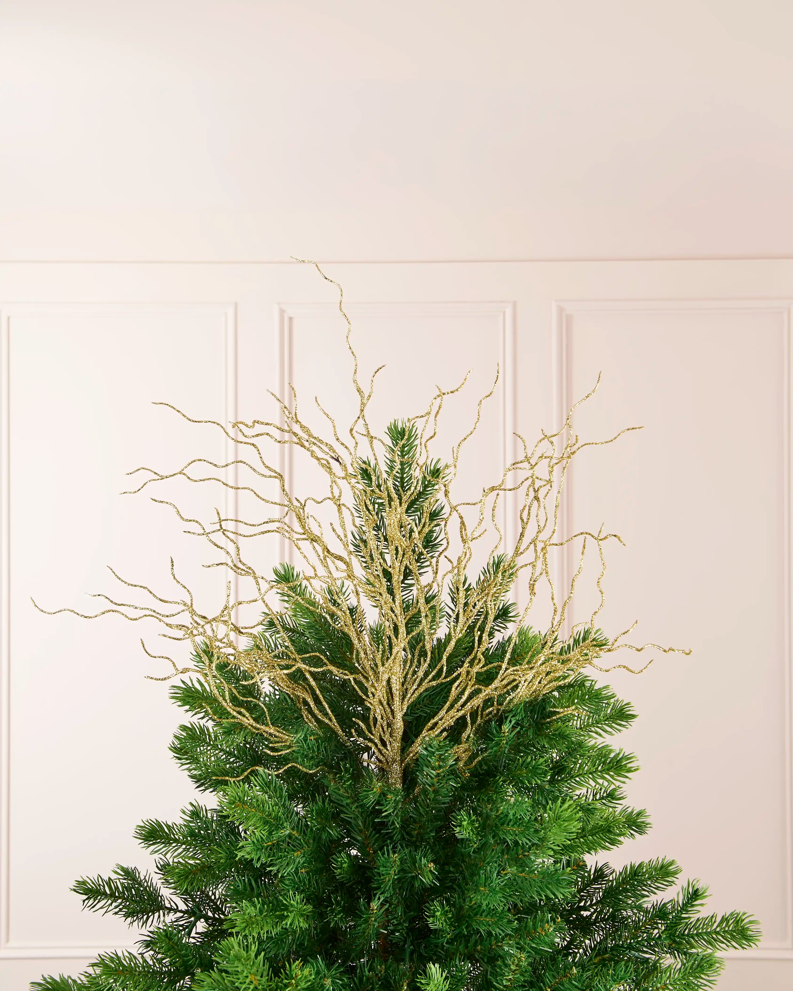 Gold 90 cm glitter twig tree topper arranged at the top of a Christmas tree.