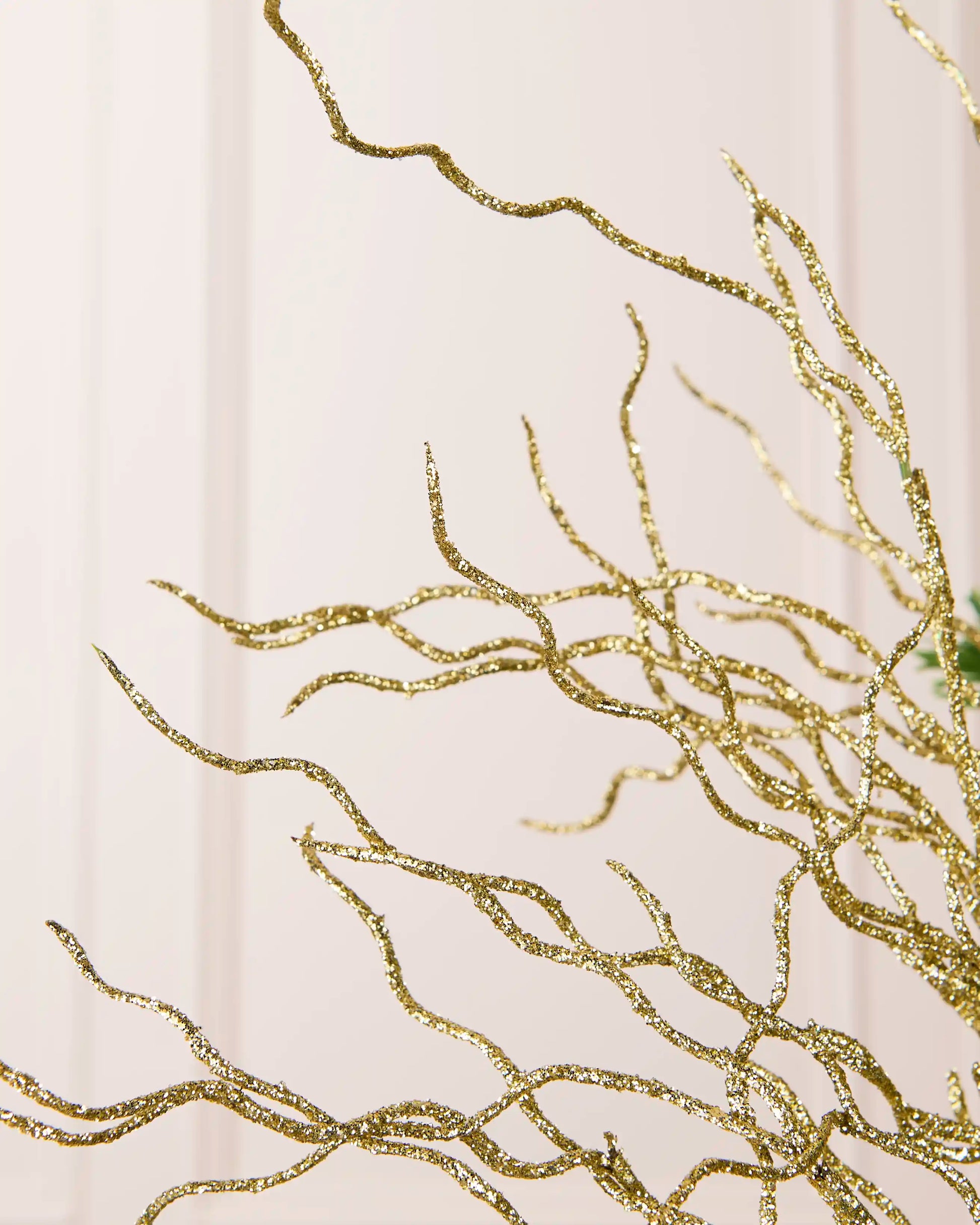 Close-up of the gold glitter and sequin finish across the branching twigs of the 90 cm tree topper.