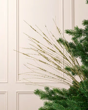 Gold 100 cm glitter wispy spray with fine sequin-accented strands arranged through an artificial Christmas tree.