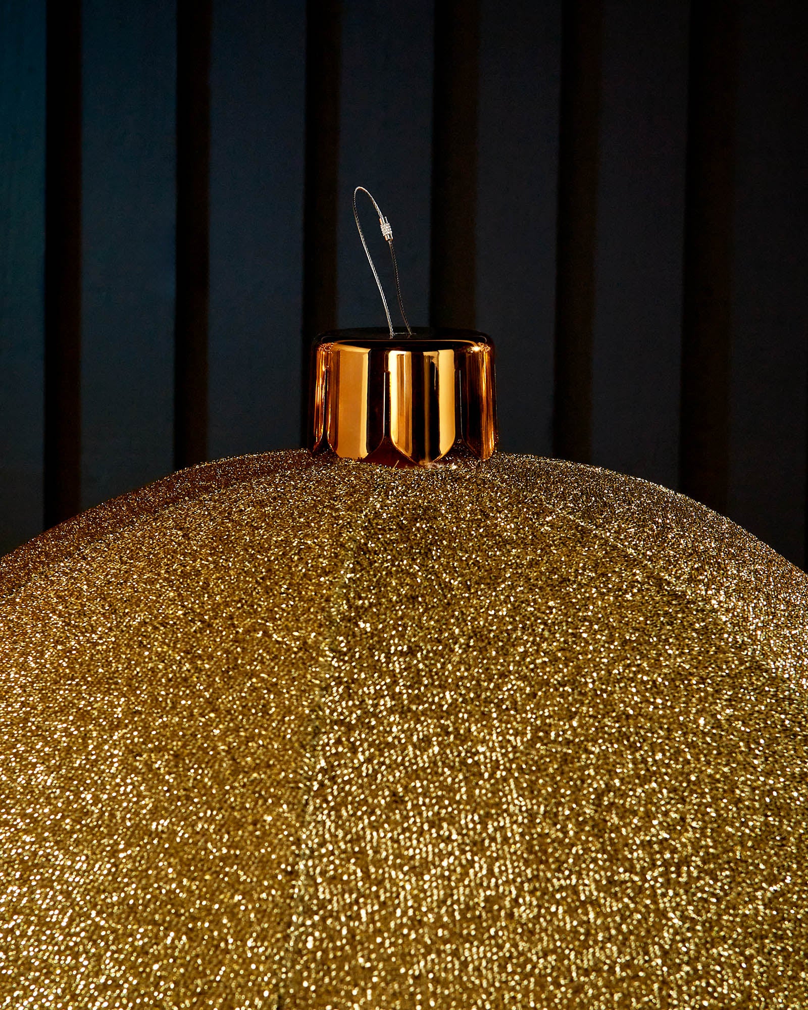 Close-up of the gold cap and hanging wire on a gold inflatable tinsel Christmas bauble.