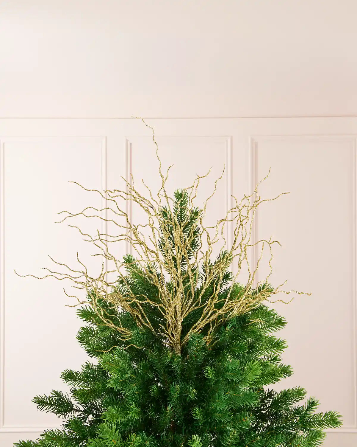 Gold 90 cm glitter twig tree topper arranged at the top of a Christmas tree.

