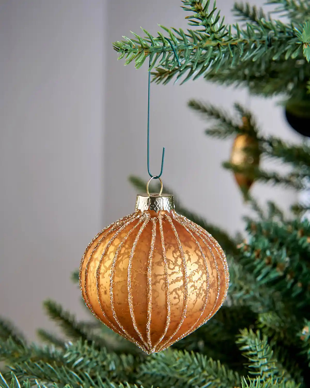 Green bauble ornament hook hanging a bauble on a Christmas tree