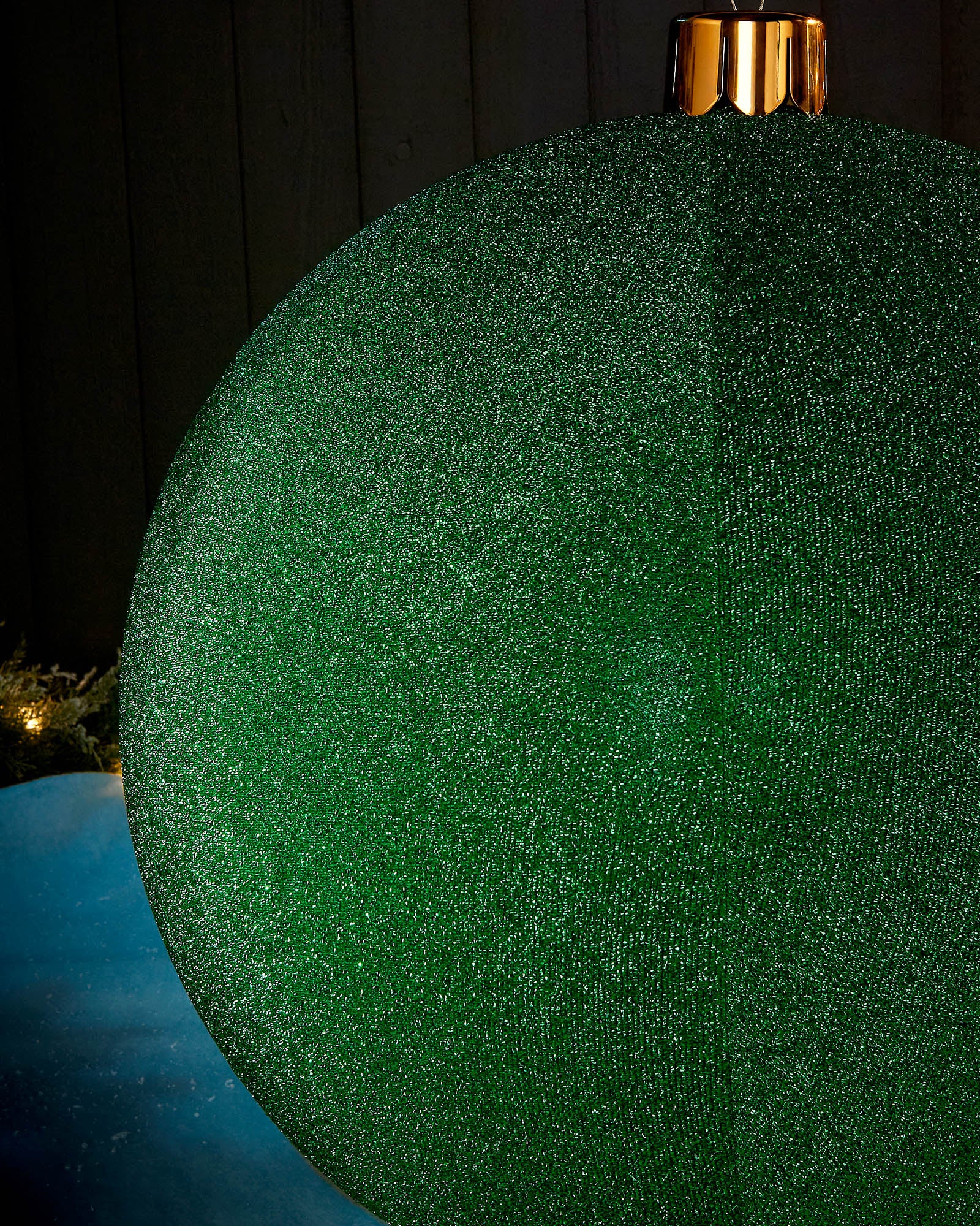 Detail close-up of the textured green tinsel surface on an inflatable Christmas bauble.