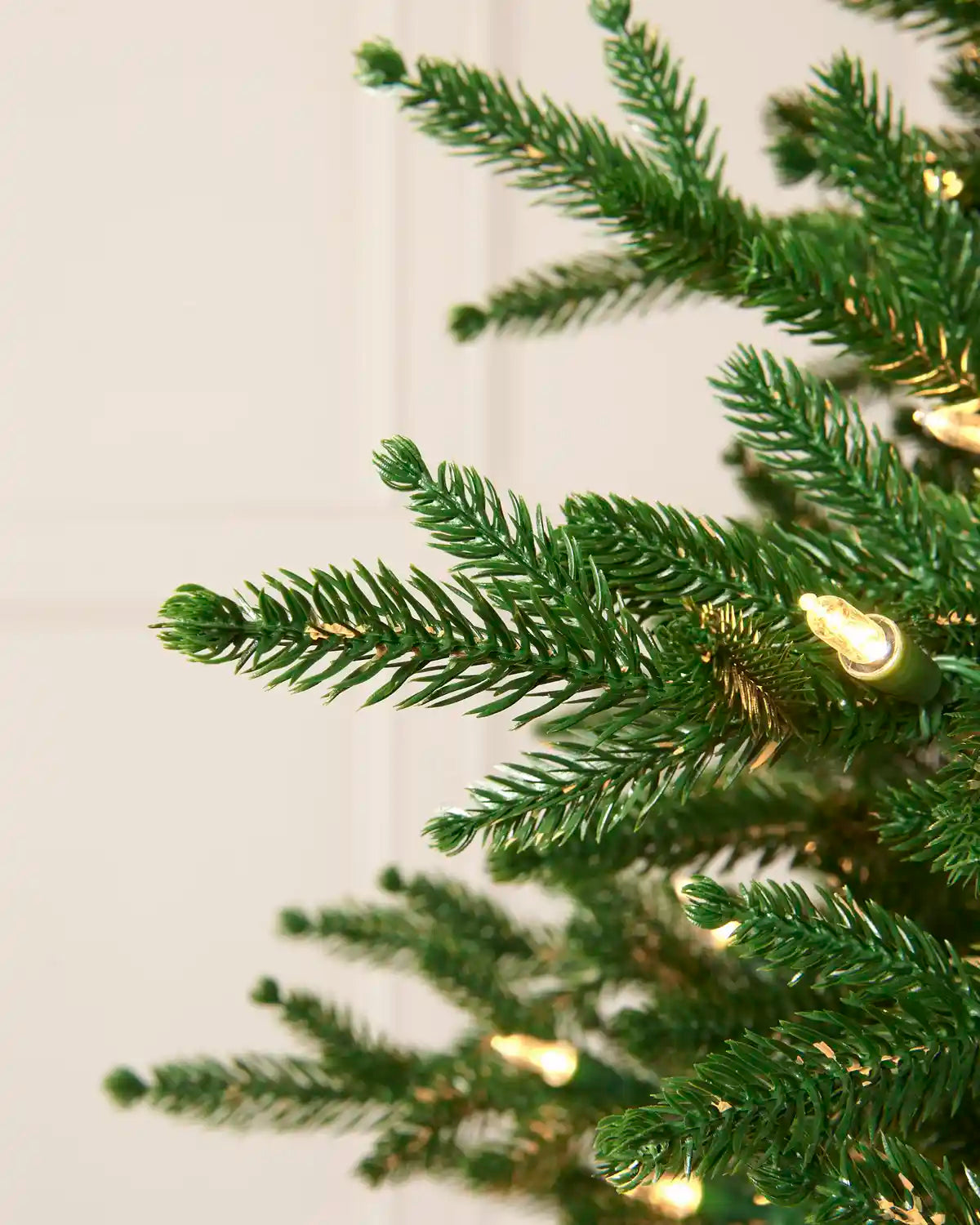 Detailed view of the realistic mixed foliage and warm white light on the Christmas tree.