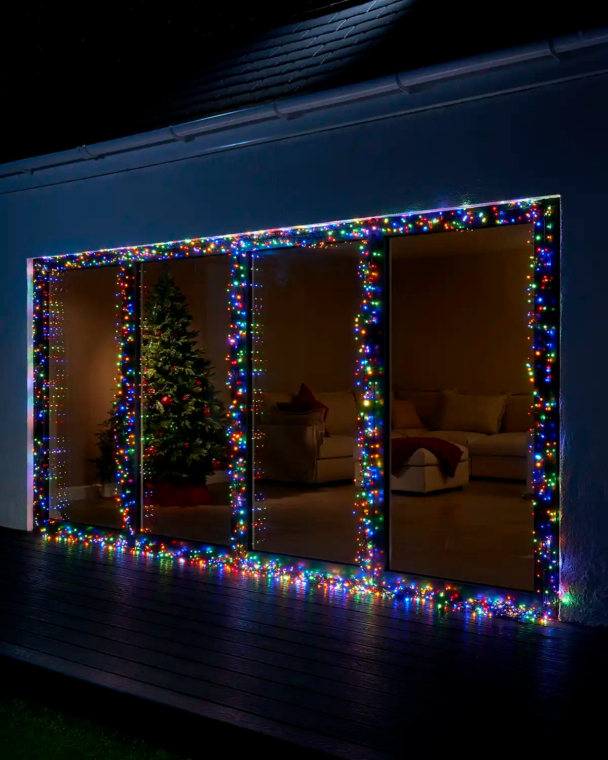 Multi colour Home Series cluster lights displayed around large patio doors at night.