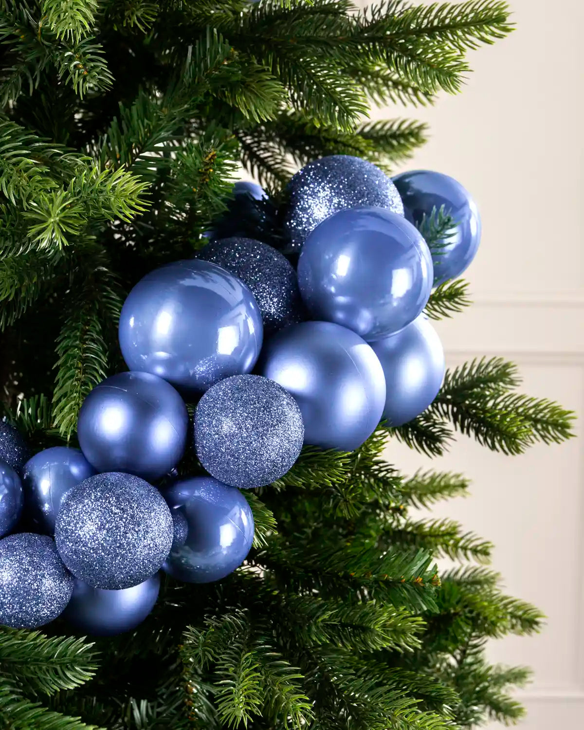 Close-up of ice blue baubles showing shiny, matt and glitter finishes on a Christmas tree.