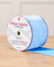 10 cm wide ice blue double-sided wired velvet ribbon on a 9 m roll with product label.