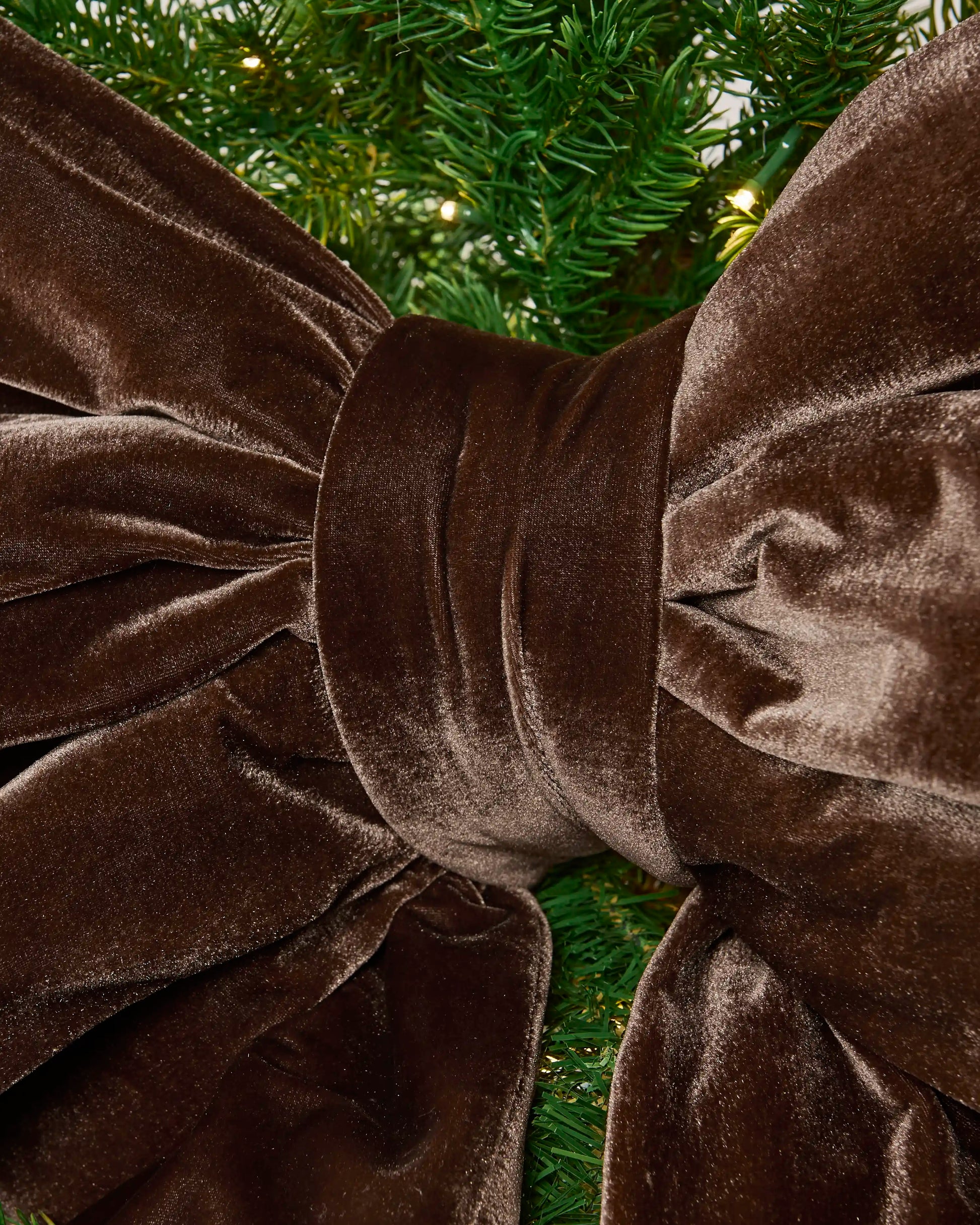 Detailed close-up of the espresso velvet Christmas bow showing the padded centre knot and gathered fabric.